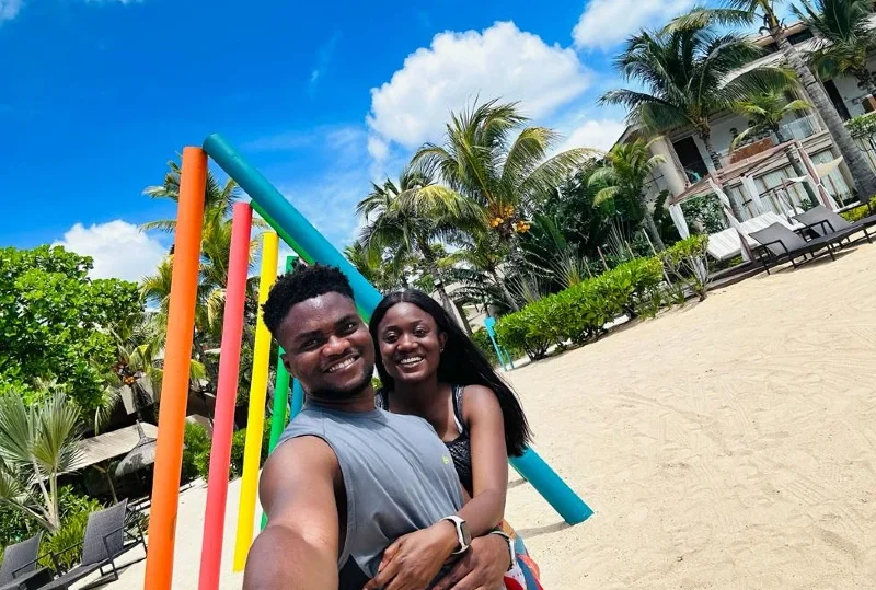 Happy couple enjoying their time at a tropical beachside resort, surrounded by palm trees and colorful decor, perfect for a unique honeymoon destination