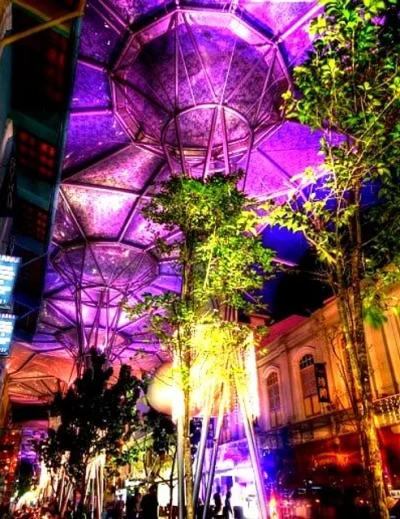 Illuminated Clarke Quay at night in Singapore with vibrant lights and modern architecture.