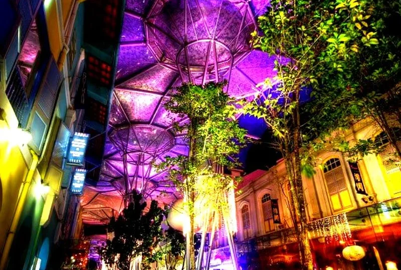 Illuminated Clarke Quay at night in Singapore with vibrant lights and modern architecture.