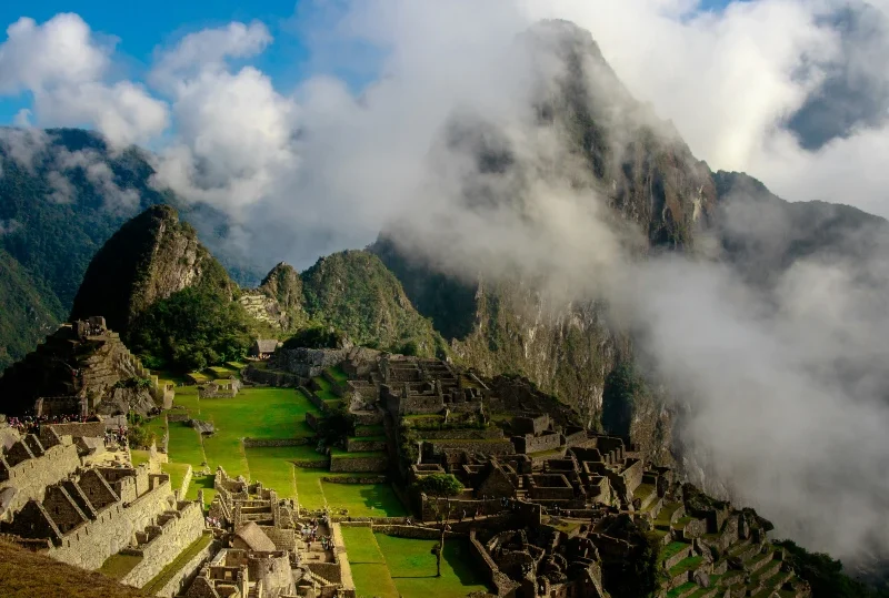 "A panoramic view of the ancient Incan city of Machu Picchu with mist-covered mountains in the background."