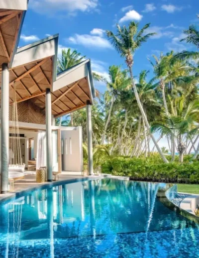 A luxurious villa with an infinity pool surrounded by lush palm trees in Seychelles, showcasing the ultimate paradise island experience.