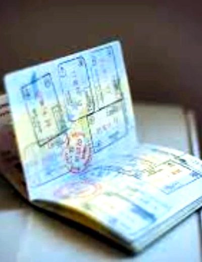 "An open passport displaying several immigration stamps, illustrating international travel requirements for a Nigerian tourist visa with Lery Hago Travels."