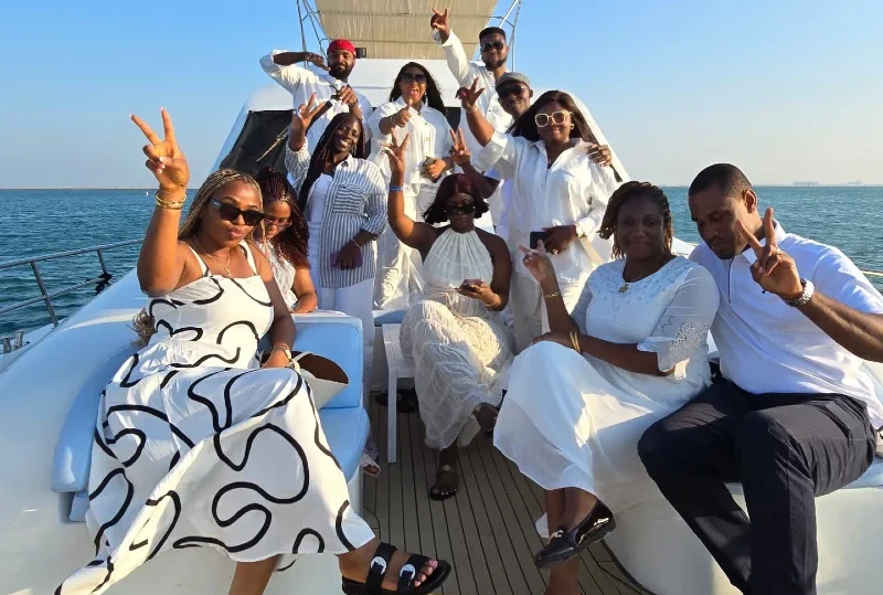 "A vibrant group of friends dressed in elegant white attire enjoying a luxury yacht cruise, embodying relaxation and joy, curated by Lery Hago Travels."