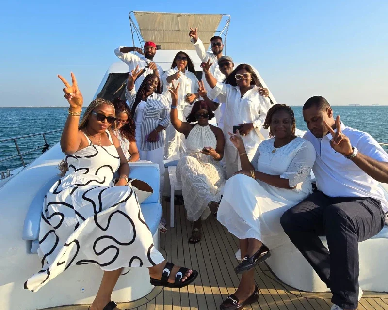 "A vibrant group of friends dressed in elegant white attire enjoying a luxury yacht cruise, embodying relaxation and joy, curated by Lery Hago Travels."