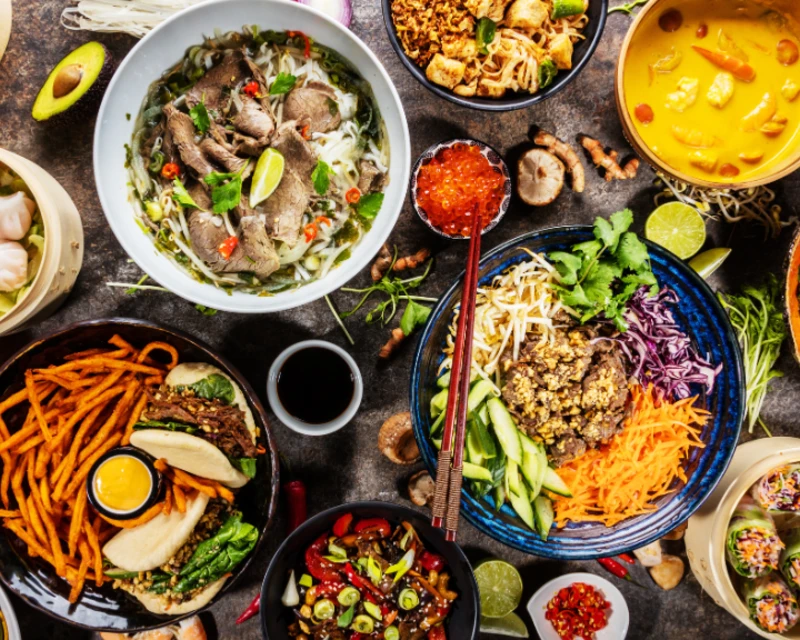 "An array of vibrant international dishes including pho, curry, and salads representing diverse culinary cultures, featured at Africa’s 2nd gastronomy tourism forum, with Lery Hago as a key promoter."