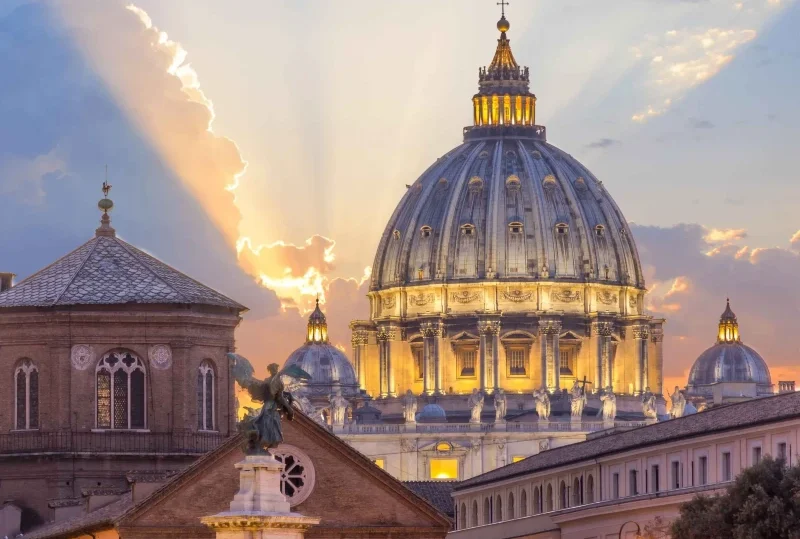 "A stunning view of St. Peter's Basilica in Vatican City illuminated at sunset, a key destination for the 2025 Catholic Jubilee in Rome."