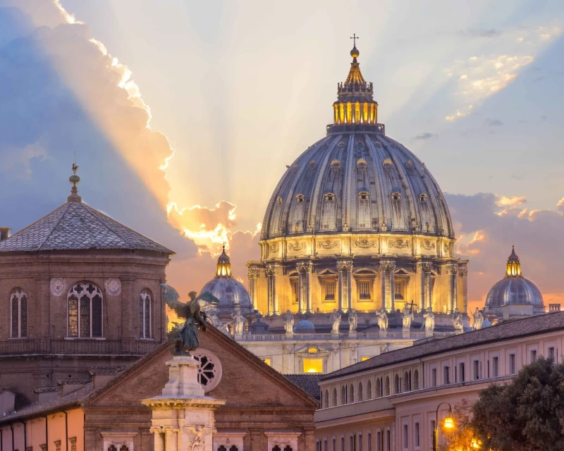 "A stunning view of St. Peter's Basilica in Vatican City illuminated at sunset, a key destination for the 2025 Catholic Jubilee in Rome."