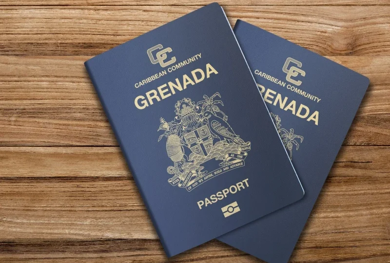 Two Grenada passports on a wooden surface representing the Citizenship by Investment opportunity for Nigerians through Leryhago.