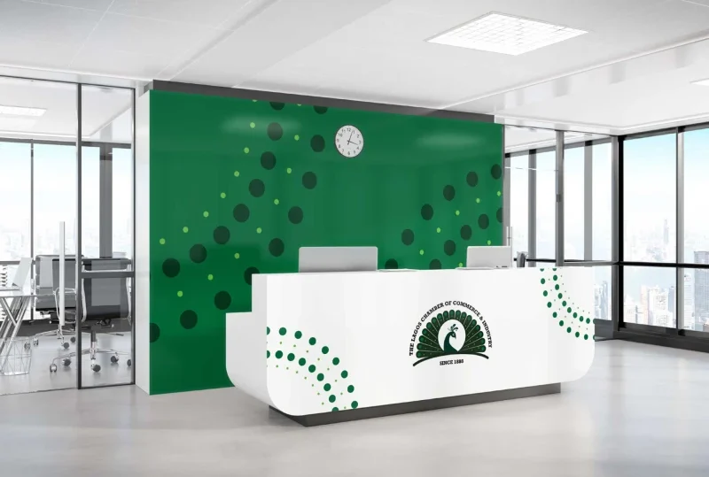 Reception area of the Lagos Chamber of Commerce and Industry (LCCI) featuring a green backdrop with circular patterns and a branded front desk.