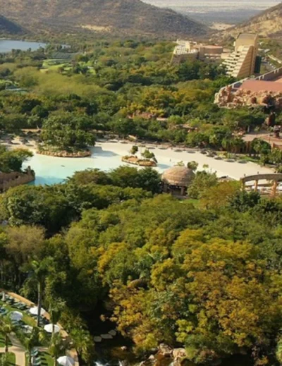 Aerial view of Sun City Resort surrounded by lush greenery, water features, and architectural landmarks in South Africa.