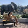 "Woman relaxing on a bench, admiring the elephant fountain sculptures in a Dubai garden, included in the Christmas Dubai Luxury Package."