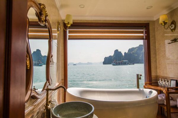"View from a luxury cruise suite in Vietnam overlooking the iconic limestone karsts in Ha Long Bay, included in the Romantic Vietnam Getaway Package."