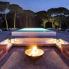 "An elegant outdoor pool area with a fire pit and loungers surrounded by a tranquil forest at Lisbon Cultural Getaway - leryhago.com"