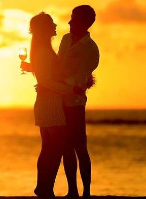 "Silhouette of a couple sharing a romantic moment with a wine toast against a stunning sunset on a leisure vacation - www.leryhago.com."