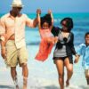 "Family joyfully walking along the shallow waters of Mombasa beach during Christmas"