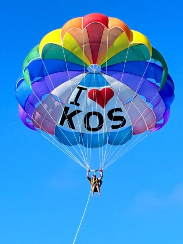 "Colorful hot air balloon with 'I Love Kos' text soaring in the bright blue sky, capturing the adventurous spirit of Pre-Christmas Magic in Mauritius."