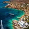 "Aerial view of a luxury yacht on the clear blue waters near Malta's rugged coastline with white houses, highlighting a Malta Historical Getaway, image via www.leryhago.com."