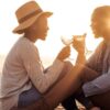 "A couple toasting with wine glasses on a beach at sunset, encapsulating the romantic spirit of a Venice Valentine's Getaway - discover more at www.leryhago.com."