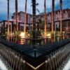 "Mövenpick hotel exterior at dusk with illuminated fountains and palm trees, offering a sophisticated venue for a Marrakech Love Getaway, featured by www.leryhago.com."