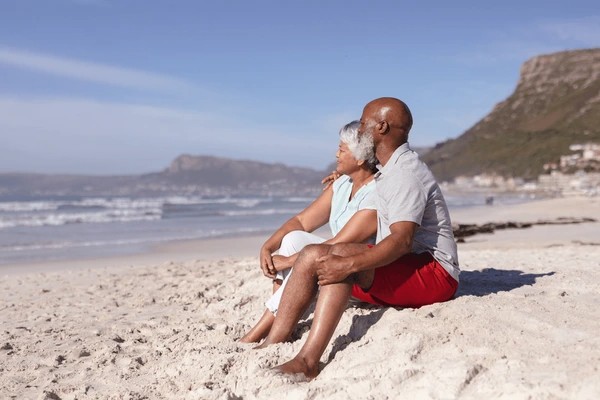 "Senior African-American couple in a tender moment, gazing at the sea on a Paris Love Getaway, featured at www.leryhago.com."
