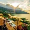 "Sunset view of a luxury hillside resort overlooking the calm sea in Vietnam, ideal for romantic getaways."