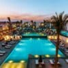 "Elegant resort pool at dusk, surrounded by palm trees and lounges, a gem for Egyptian Romantic Adventures at www.leryhago.com."
