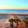 "A wooden boardwalk leads to a beach with a breathtaking sunset, an idyllic scene for a Romantic Getaway in New Orleans - find out more at www.leryhago.com."