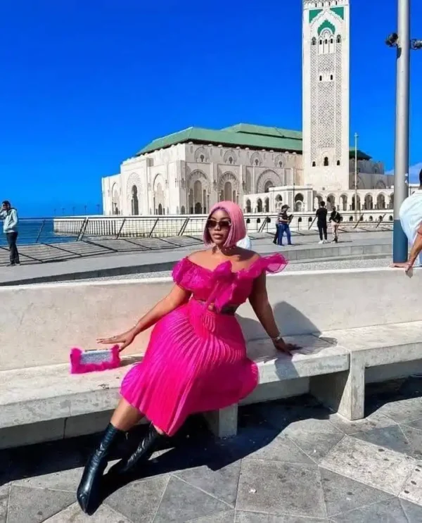 "Fashion-forward traveler in a vibrant pink dress posing in front of an iconic mosque in Doha, a sightseeing highlight from the Qatar Doha Package | www.leryhago.com"