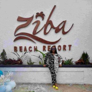 "Chic traveler posing in front of the iconic Ziba Beach Resort sign, a prime Naija Easter Getaway spot featured on www.leryhago.com."