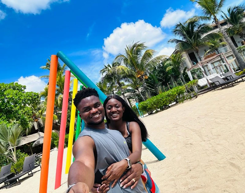 Happy couple enjoying their time at a tropical beachside resort, surrounded by palm trees and colorful decor, perfect for a unique honeymoon destination