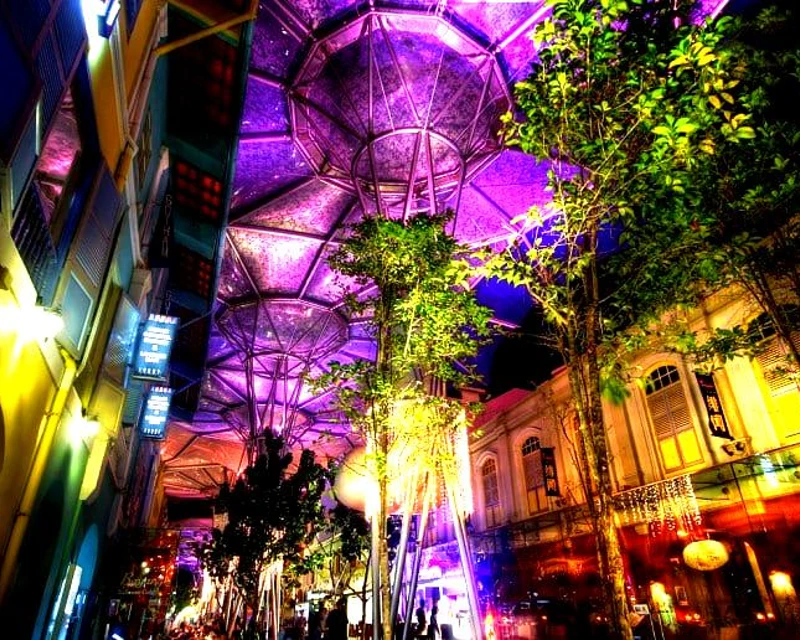 Illuminated Clarke Quay at night in Singapore with vibrant lights and modern architecture.