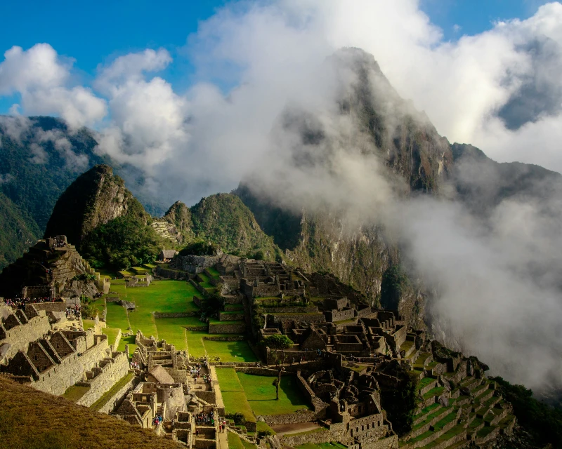 "A panoramic view of the ancient Incan city of Machu Picchu with mist-covered mountains in the background."