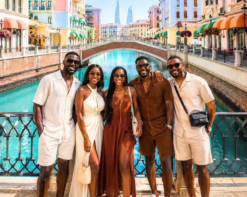 A group of stylishly dressed africans standing on a bridge in the pearl Doha.